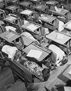 children hiding under school desks in 1950s nuclear drill