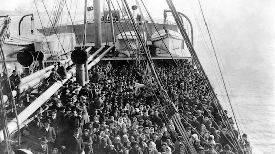 Immigrants on ship deck in New York harbor