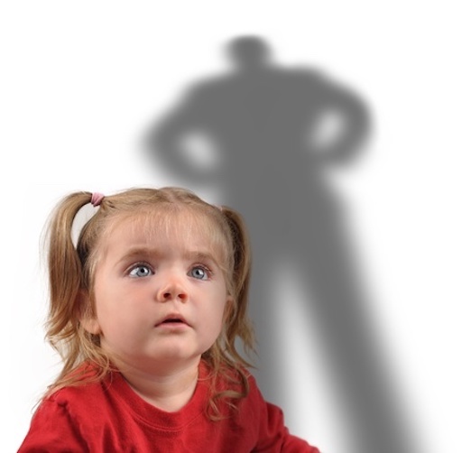 Frightened little girl looking up at shadow 